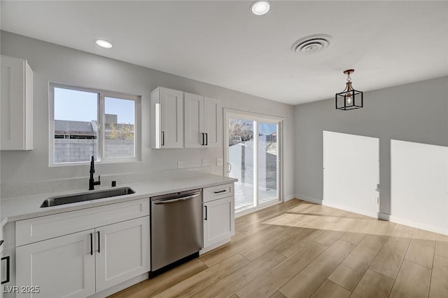 kitchen featuring sink, pendant lighting, white cabinets, and stainless steel dishwasher