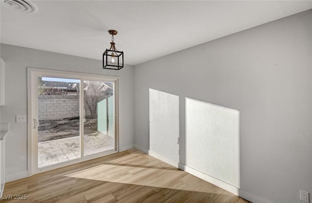 unfurnished dining area featuring light wood-type flooring