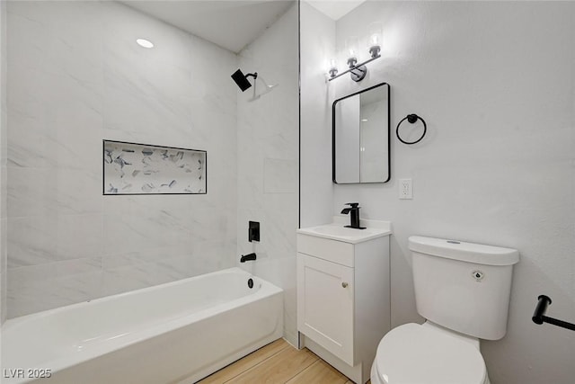 full bathroom featuring hardwood / wood-style floors, toilet, vanity, and tiled shower / bath