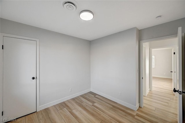 unfurnished bedroom with light hardwood / wood-style floors and a closet