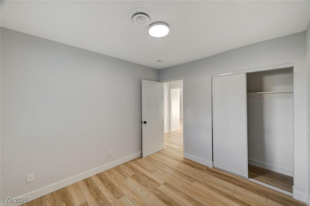 unfurnished bedroom with a closet and light hardwood / wood-style flooring