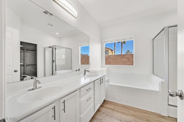 bathroom featuring vanity, hardwood / wood-style floors, and separate shower and tub