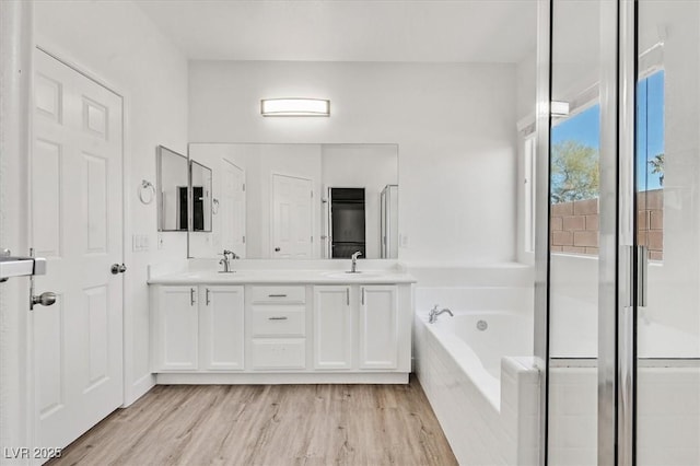 bathroom with shower with separate bathtub, wood-type flooring, and vanity