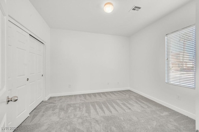 unfurnished bedroom with a closet and light carpet