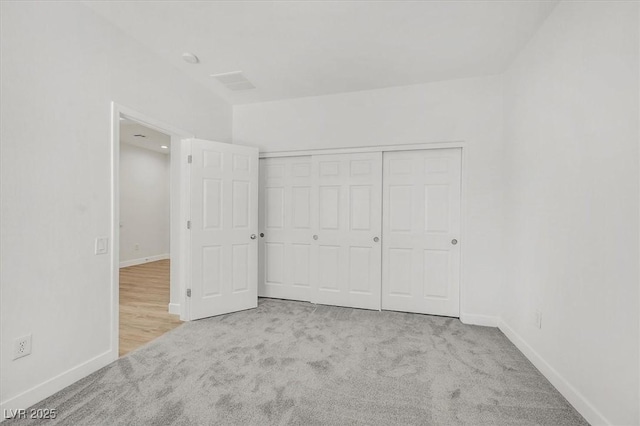 unfurnished bedroom featuring a closet and light carpet