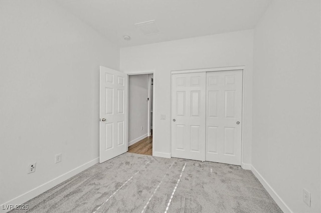 unfurnished bedroom with a closet and light carpet