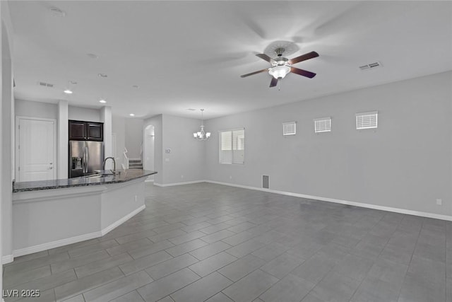 unfurnished living room featuring ceiling fan with notable chandelier, sink, and tile patterned flooring