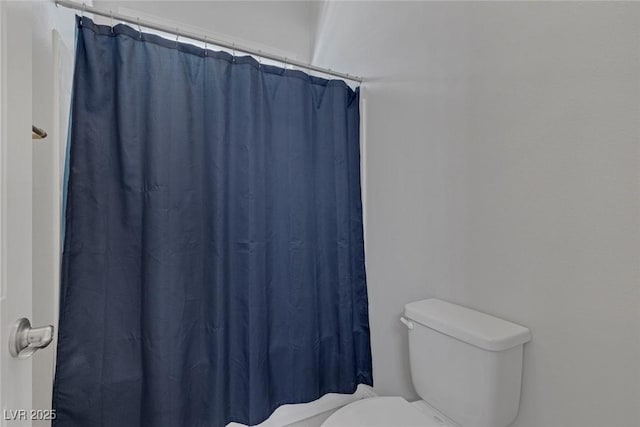 bathroom featuring toilet and a shower with shower curtain