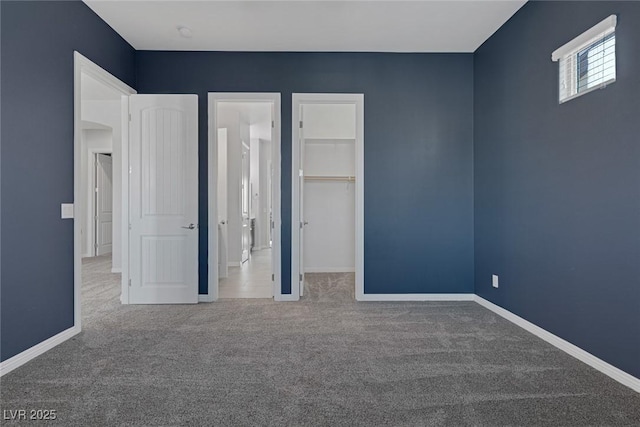 unfurnished bedroom with a spacious closet, carpet, and a closet