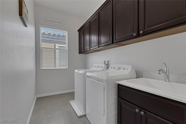 washroom featuring cabinets, light tile patterned floors, sink, and washing machine and dryer