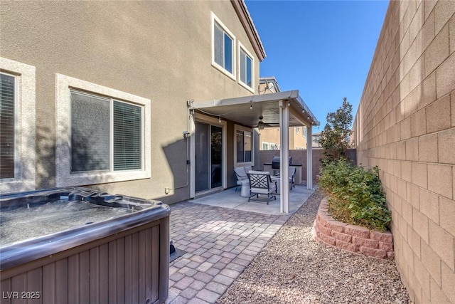 view of patio / terrace featuring ceiling fan and a hot tub