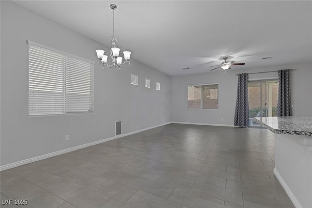 tiled spare room featuring ceiling fan with notable chandelier