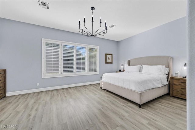 bedroom with light wood-type flooring and an inviting chandelier