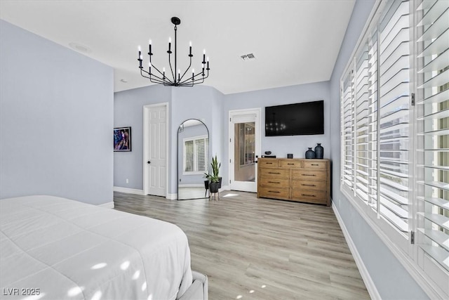 bedroom with a notable chandelier and wood-type flooring