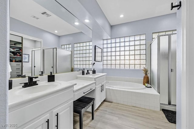 bathroom with vanity, hardwood / wood-style flooring, and plus walk in shower