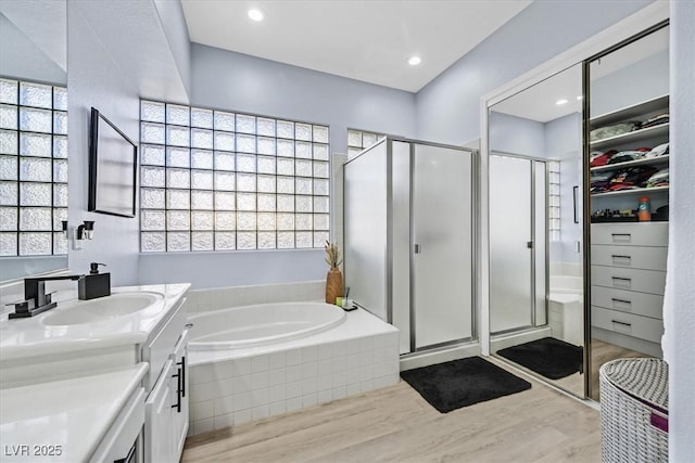 bathroom with independent shower and bath, vanity, and hardwood / wood-style flooring