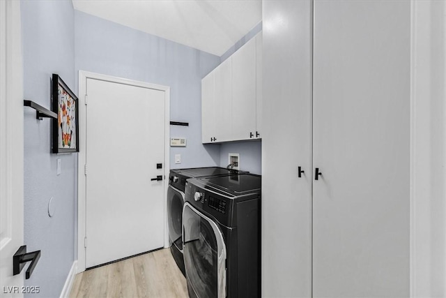 laundry room with cabinets, light wood-type flooring, and independent washer and dryer