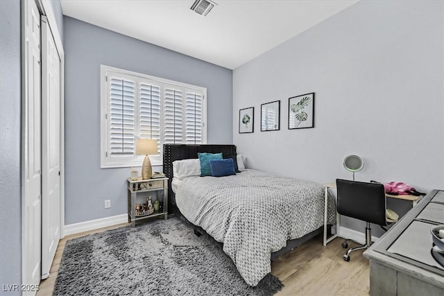 bedroom with light hardwood / wood-style flooring and a closet