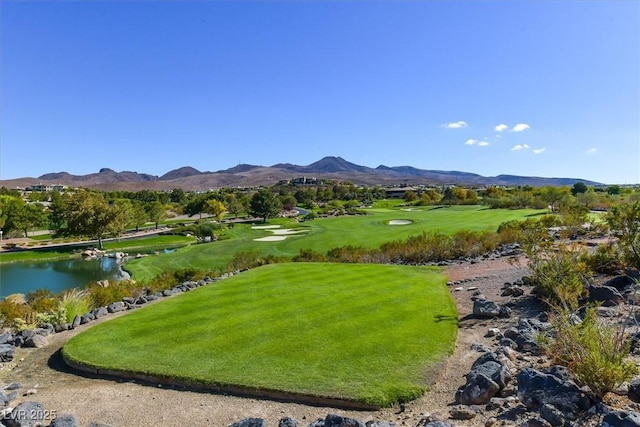 view of community featuring a water and mountain view and a yard