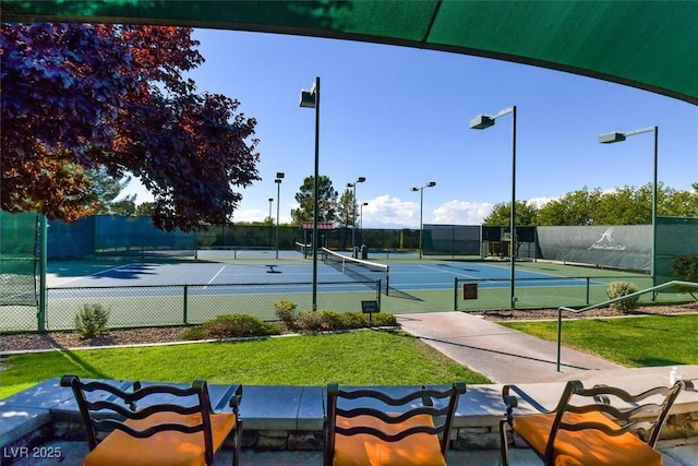 view of tennis court with a yard