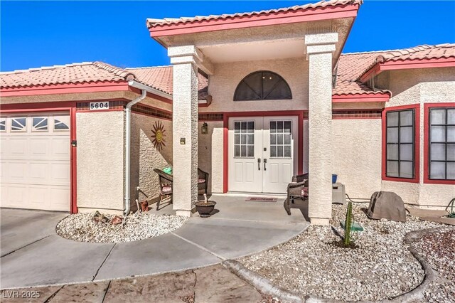 doorway to property featuring french doors and a garage