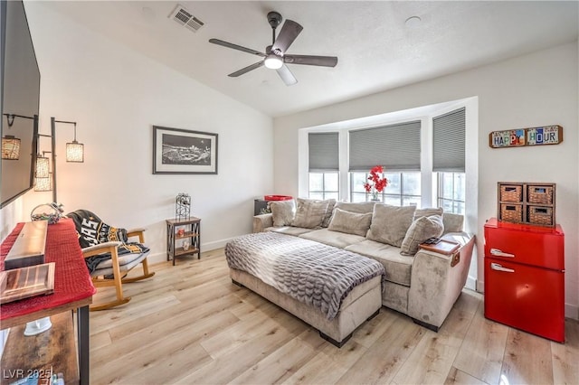 living room featuring lofted ceiling, ceiling fan, and light hardwood / wood-style flooring