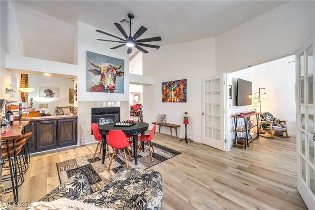 dining room with french doors, high vaulted ceiling, light wood-type flooring, and ceiling fan