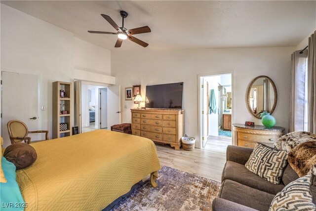 bedroom with vaulted ceiling, connected bathroom, ceiling fan, and light wood-type flooring