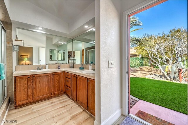 bathroom featuring lofted ceiling, vanity, and hardwood / wood-style floors