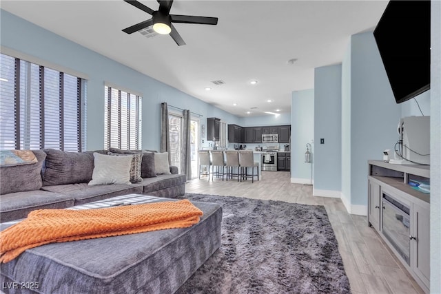 living room with ceiling fan and light hardwood / wood-style floors