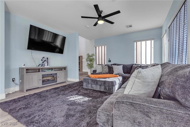 living room with ceiling fan and light wood-type flooring