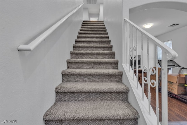 stairs featuring hardwood / wood-style floors