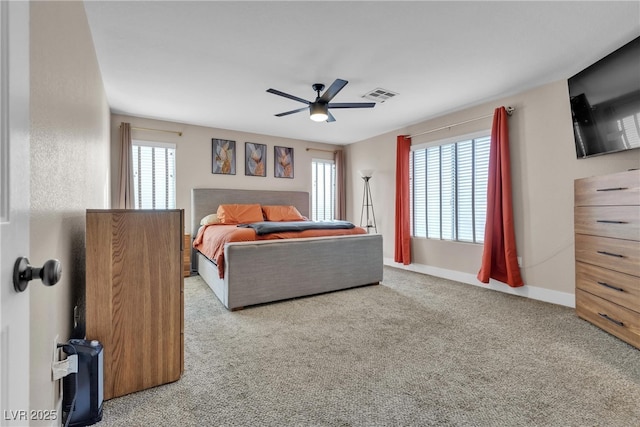 carpeted bedroom with ceiling fan and multiple windows