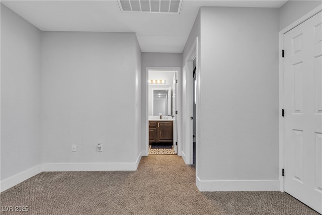 interior space featuring light colored carpet and connected bathroom