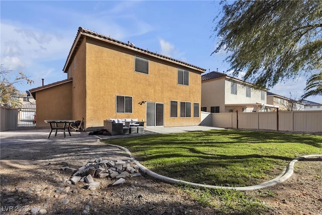 back of property with a patio, an outdoor living space, and a lawn