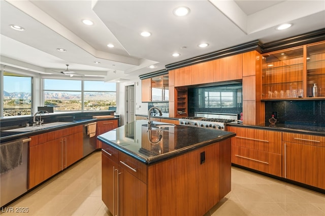 kitchen featuring ceiling fan, sink, stainless steel dishwasher, and an island with sink