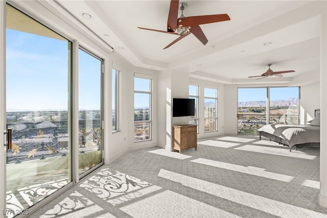 interior space with ceiling fan and a tray ceiling