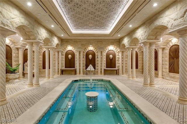 view of swimming pool with ornate columns