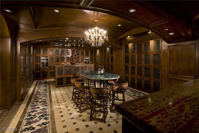 wine area featuring brick ceiling, lofted ceiling, and a notable chandelier