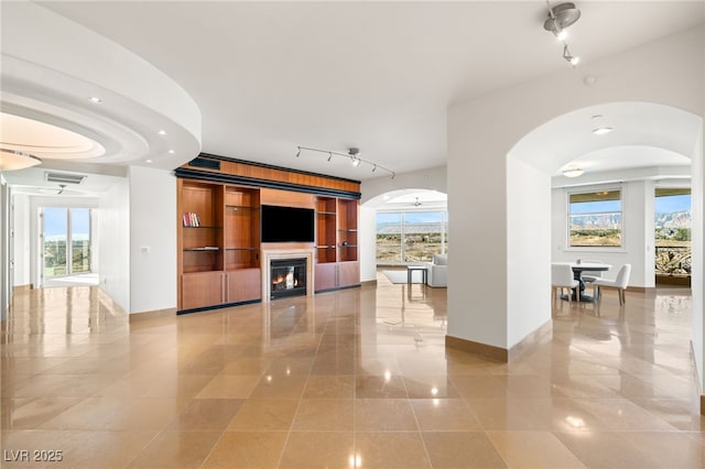 unfurnished living room with built in shelves and light tile patterned flooring