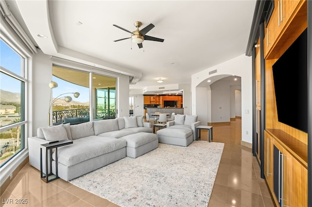 living room with ceiling fan and tile patterned floors