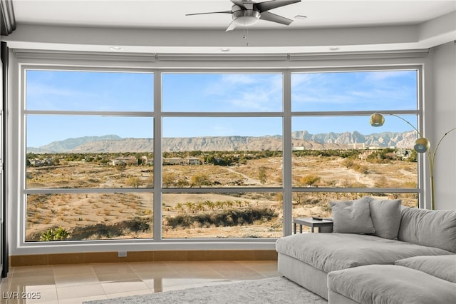 sunroom with a mountain view and ceiling fan