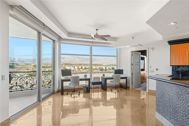 interior space with floor to ceiling windows, decorative backsplash, and ceiling fan