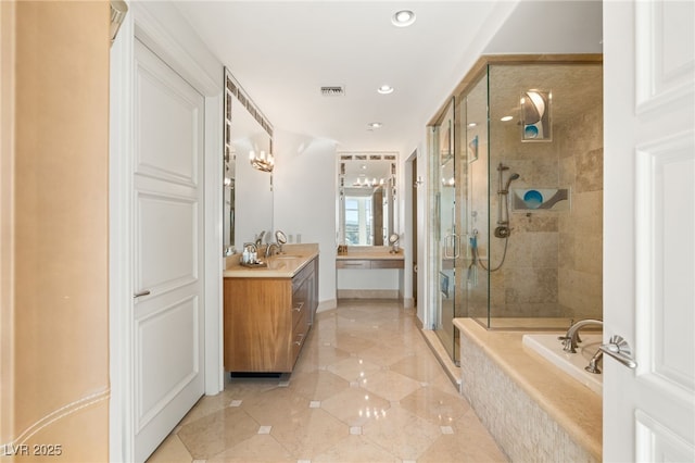 bathroom with vanity and shower with separate bathtub