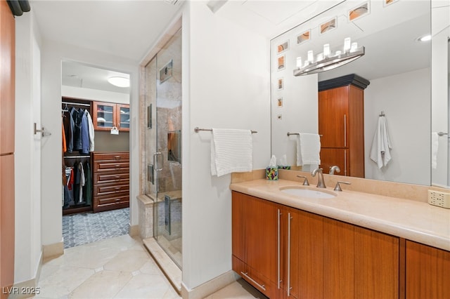 bathroom featuring a shower with shower door, vanity, and tile patterned flooring