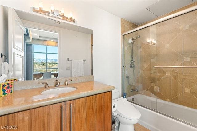 full bathroom with bath / shower combo with glass door, toilet, and vanity