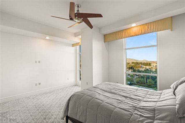 carpeted bedroom with ceiling fan and a mountain view