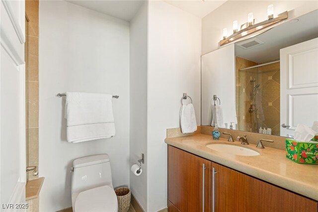 bathroom featuring toilet, vanity, and a tile shower