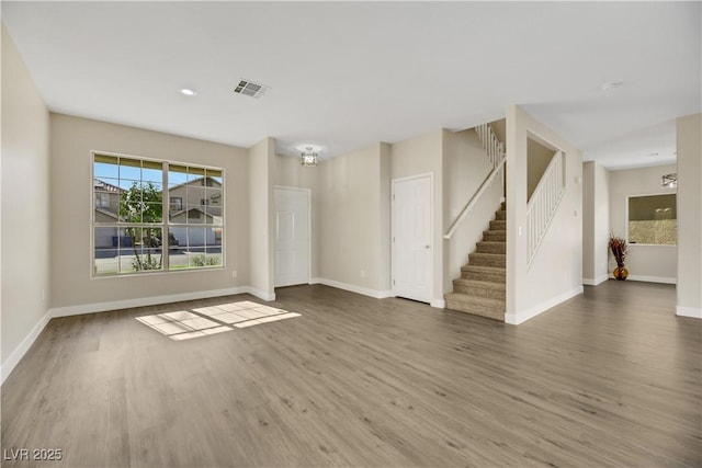 spare room with a chandelier and dark hardwood / wood-style floors