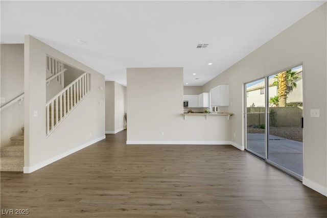 unfurnished living room with dark wood-type flooring